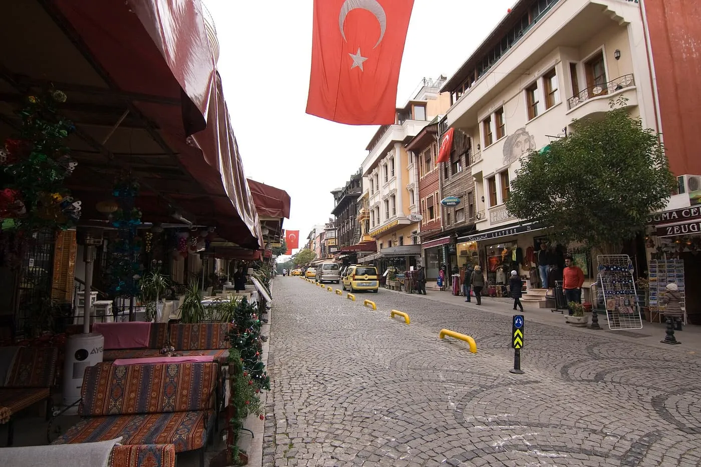 Akbıyık Caddesi, a cobbled street in Cankurtaran with café terraces on the left and Turkish flags hanging overhead