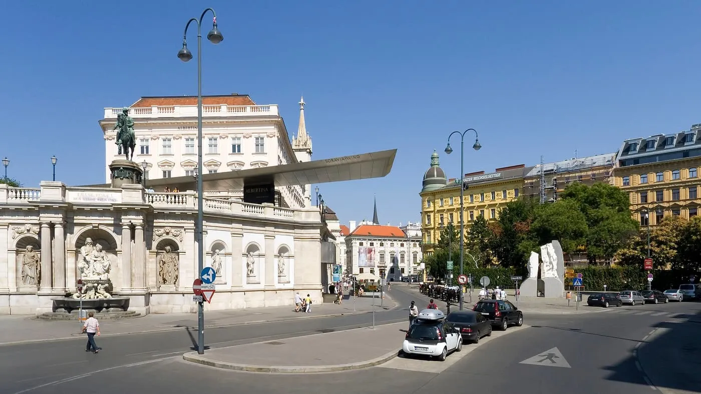 Albertinaplatz with the Albrechtsbrunnen fountain and the Albertina on its ramp, and a street of Ringstrasse-era houses to the right