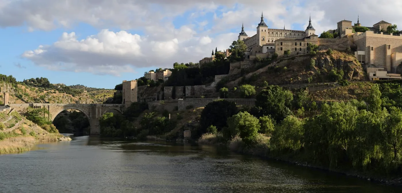 The Alcázar on its hill above the Tagus, with the Alcántara bridge and the river in the foreground