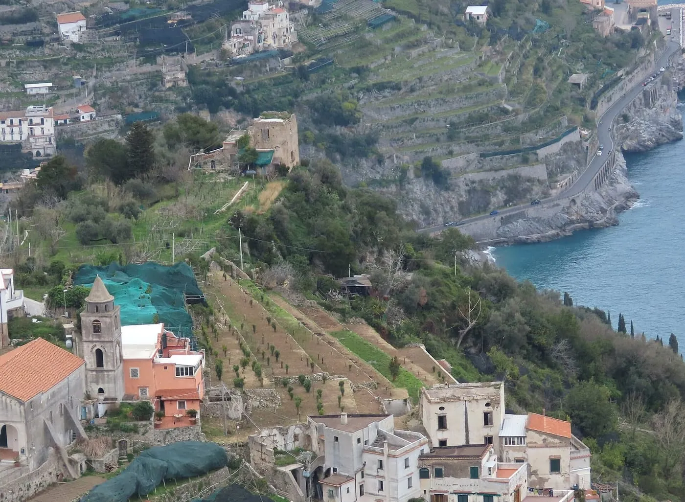 Terraced hillside above the sea on the Amalfi Coast, with the coast road cut into the cliff on the right