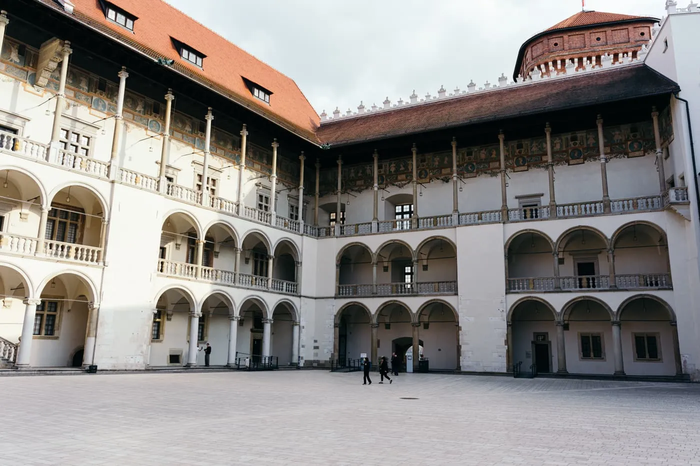 The Arcaded Courtyard of Wawel Castle, with tiers of round arches and a painted frieze under the roof