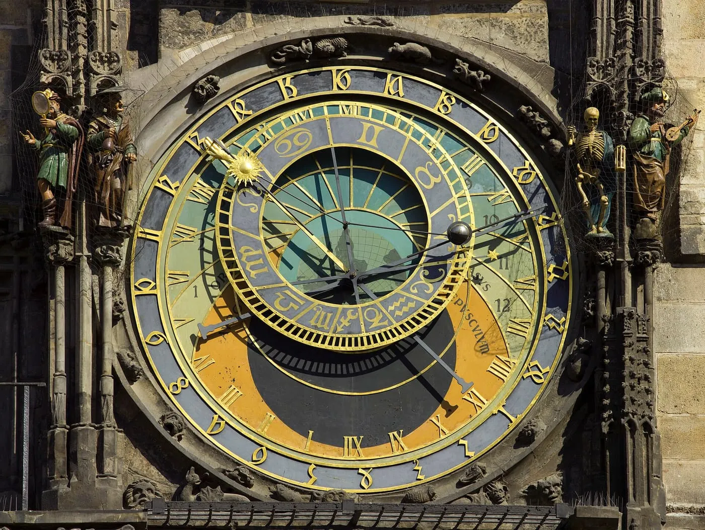 The dial of the Prague Astronomical Clock, with the figures of Vanity and the Miser on the left and Death and the Turk on the right