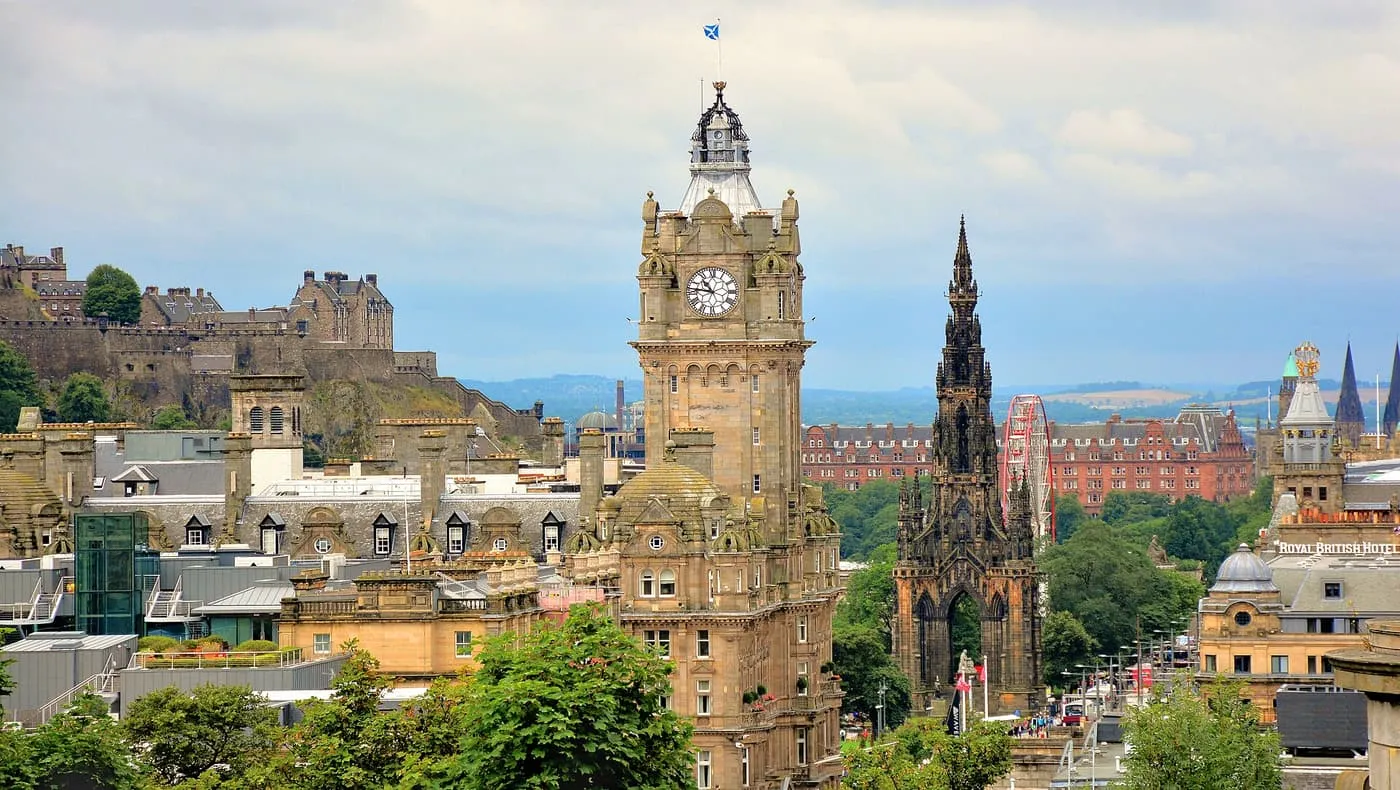 The Balmoral's clock tower beside the Scott Monument, with Edinburgh Castle on its rock at the left and the roofs of the Old Town between
