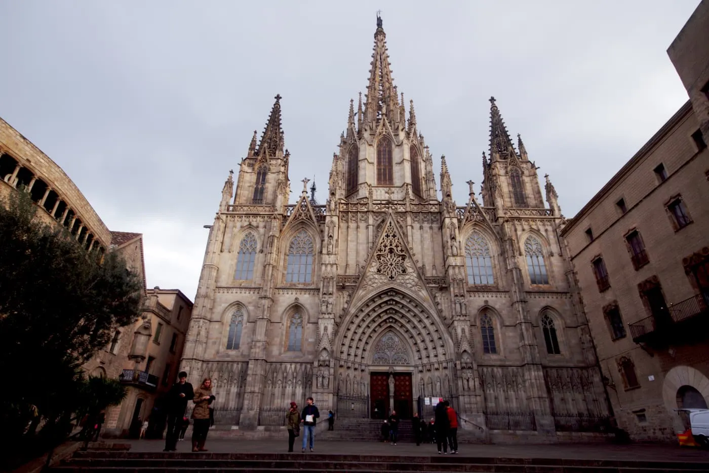 The cathedral's Gothic façade, with a central spire and two side towers, seen across the steps and the square in front of it