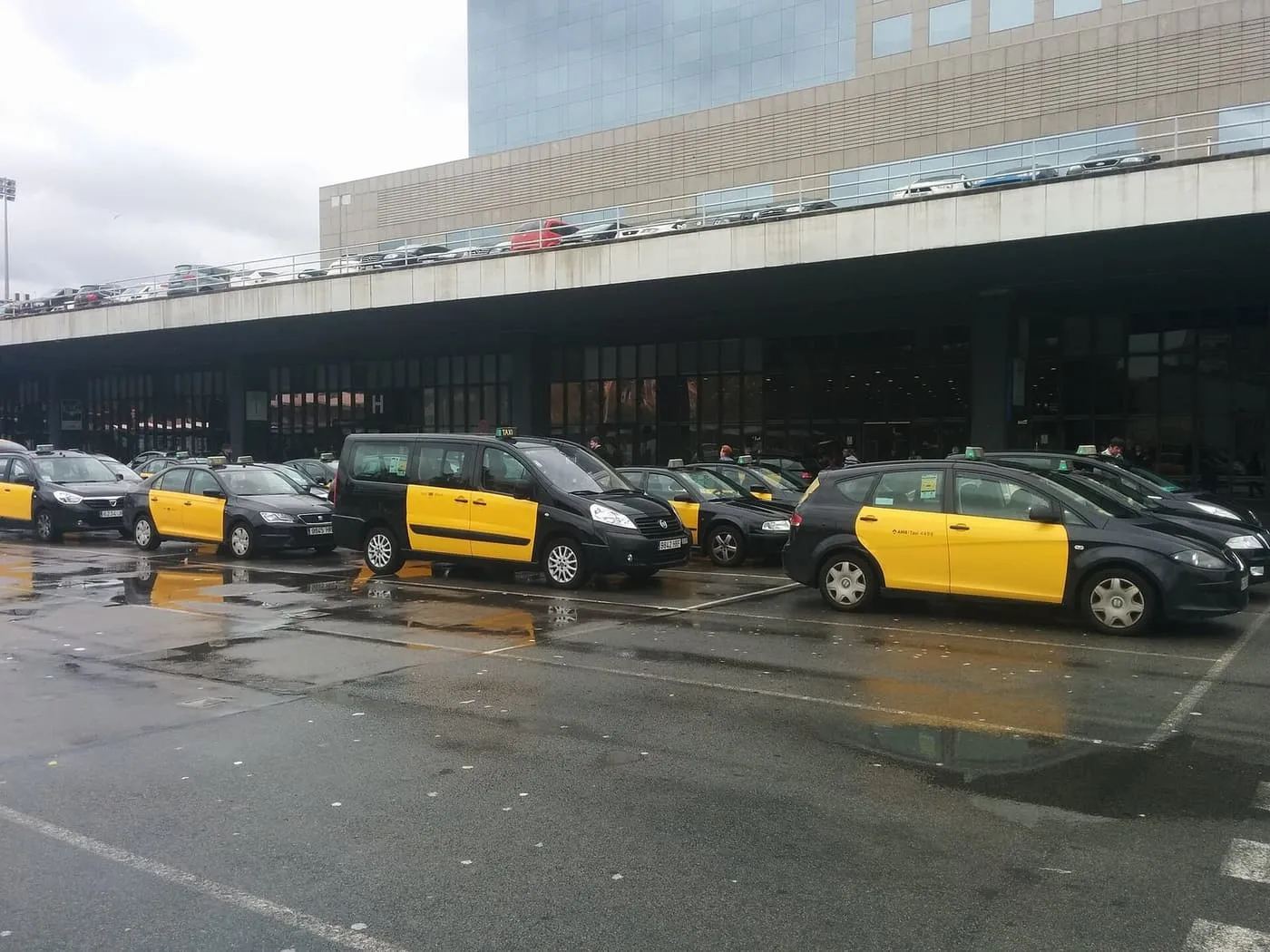 A line of black-and-yellow Barcelona taxis waiting outside Sants station