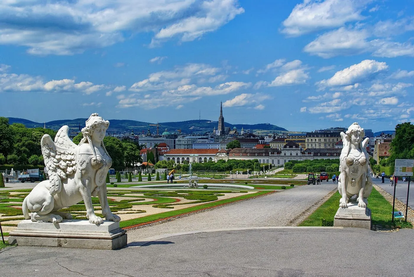 Two stone sphinxes flank the path down the Belvedere gardens, with clipped parterres and the city beyond
