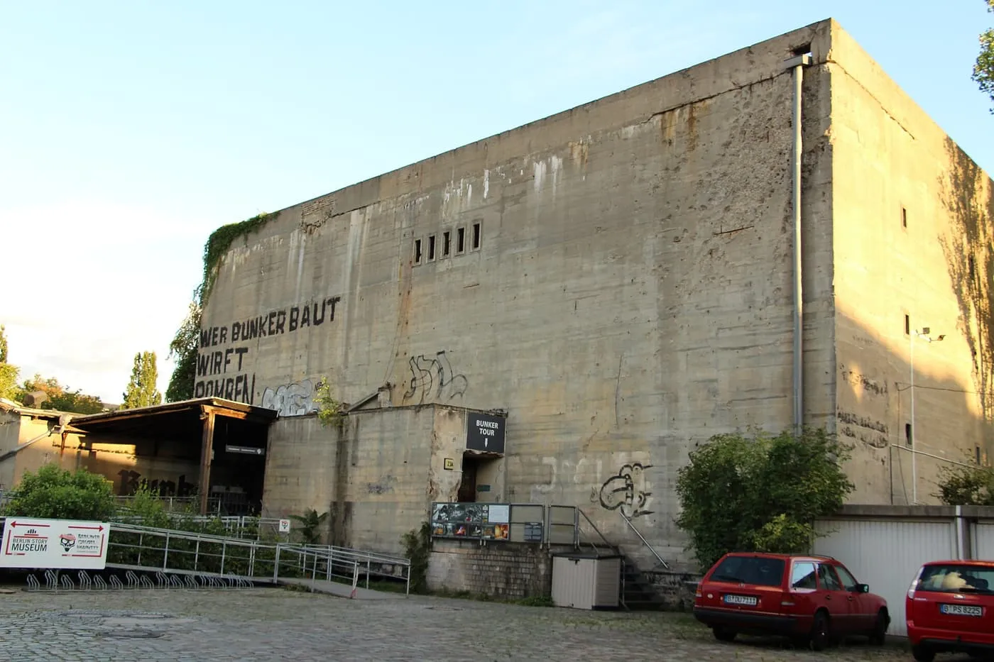 The windowless concrete wall of the Berlin Story Bunker on Schöneberger Straße, with a Bunker Tour sign at its entrance