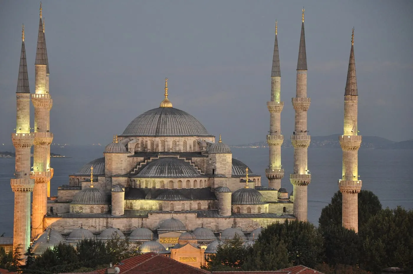 The Blue Mosque at dusk, its domes and six minarets floodlit against the Sea of Marmara