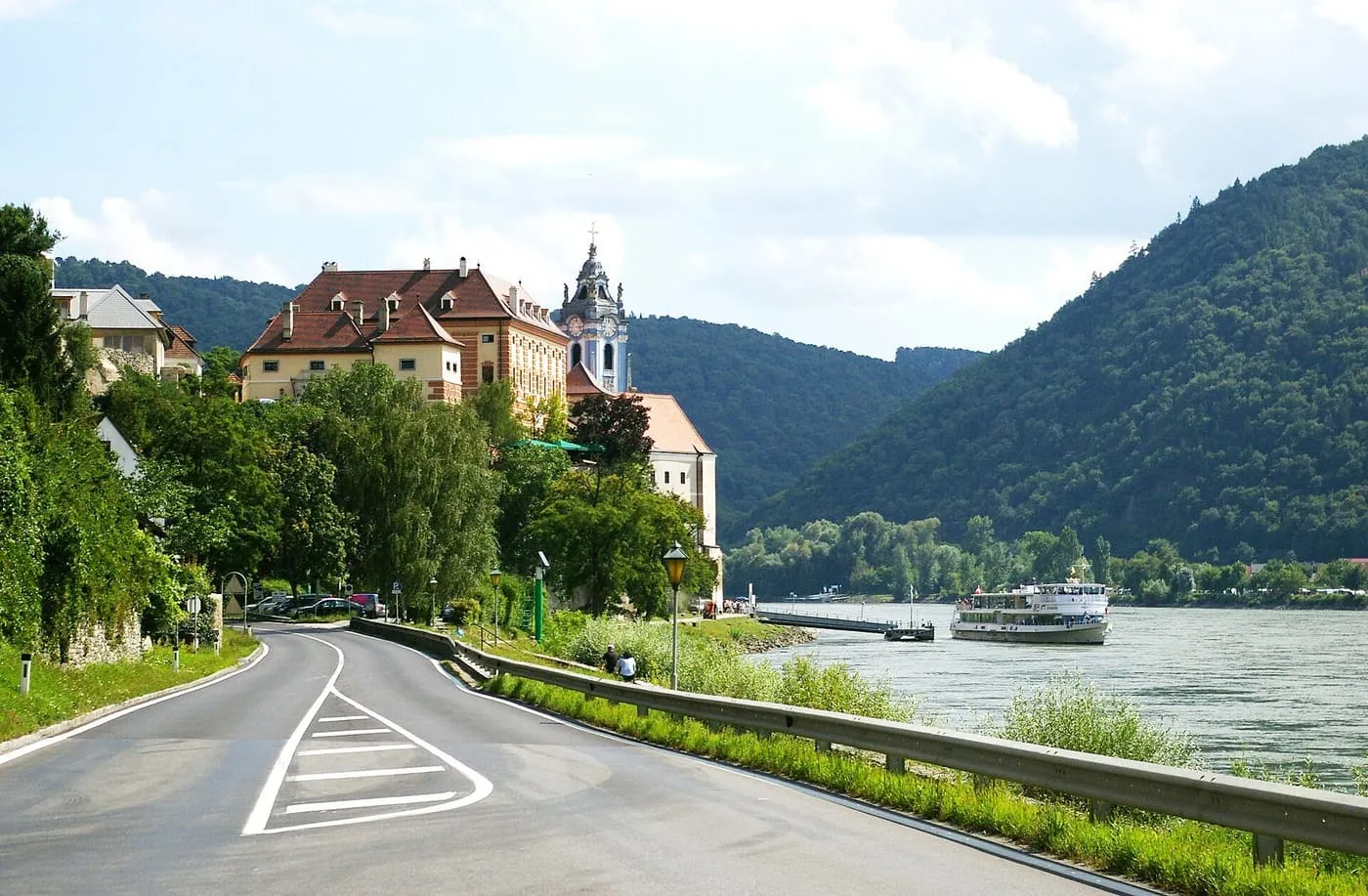 A passenger boat on the Danube below Dürnstein, with the abbey's blue tower among the trees