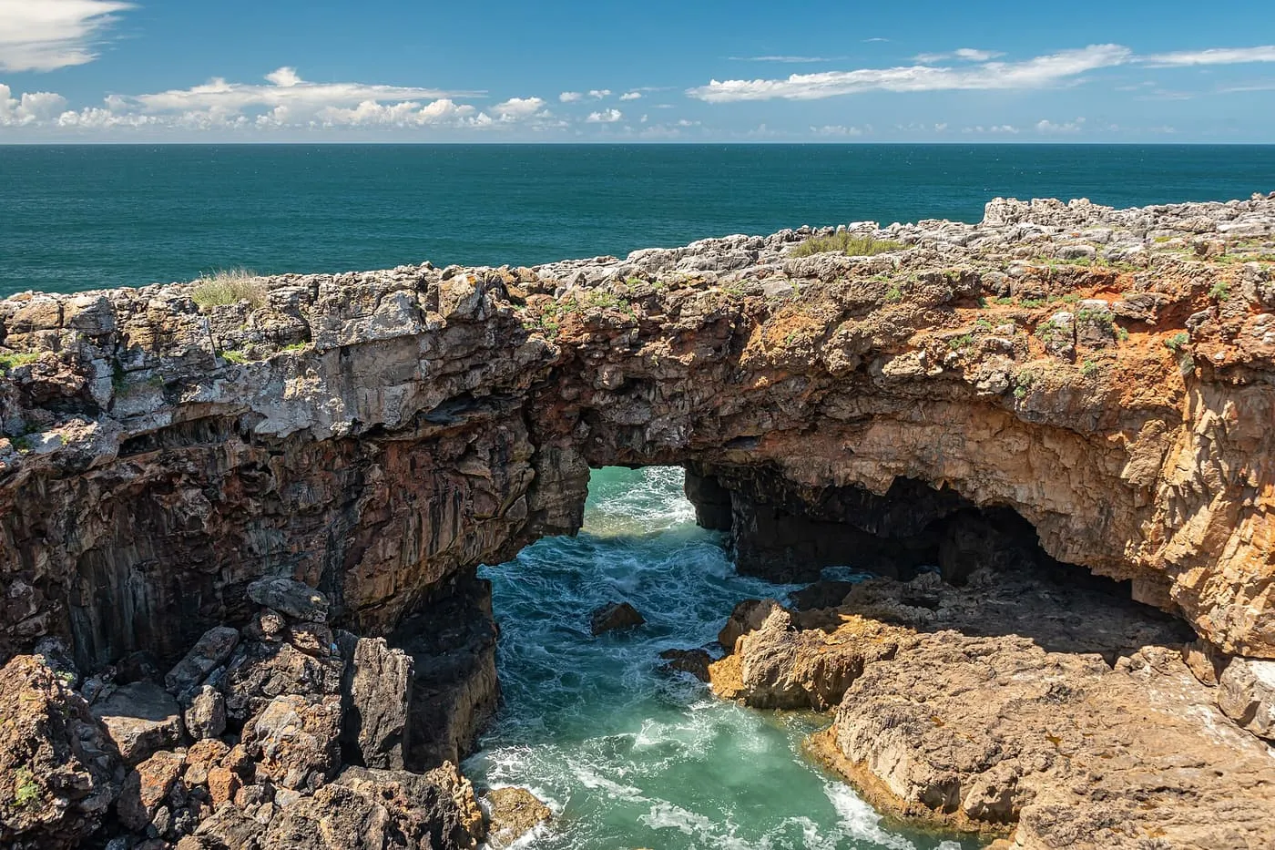 The Boca do Inferno, a natural rock arch with green Atlantic water surging through it below