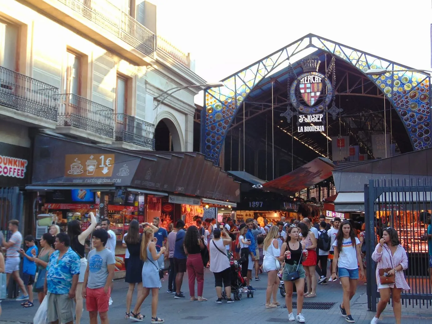 The iron-and-glass entrance of the Boqueria market on La Rambla, with its Mercat de Sant Josep sign, and a crowd in front