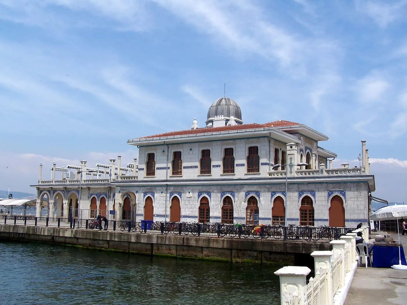 The domed, tiled ferry terminal on the water at Büyükada, with rows of bicycles along its railings