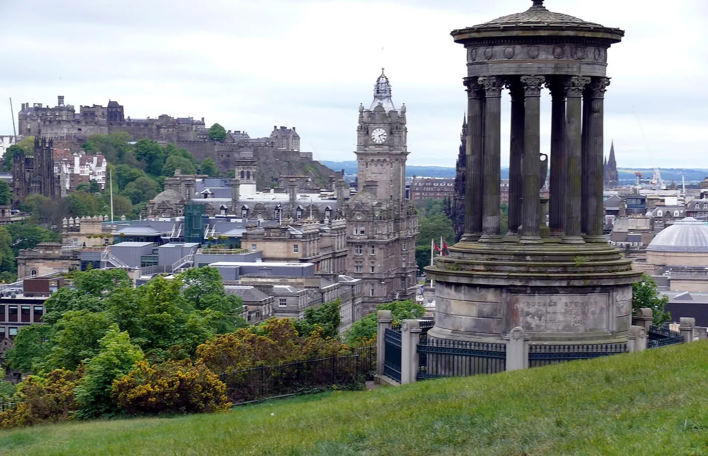 The Dugald Stewart Monument on Calton Hill, with the Balmoral clock tower and Edinburgh Castle across the city beyond