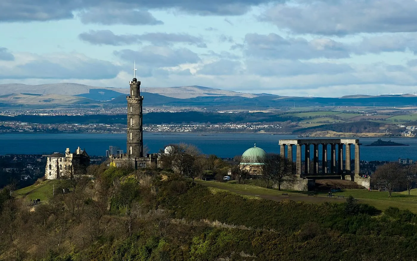 The Nelson Monument tower, the City Observatory dome and the columns of the National Monument on Calton Hill, with the Firth of Forth behind