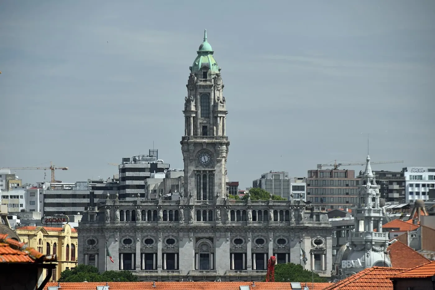The grey granite Câmara Municipal with its tall clock tower above the rooftops
