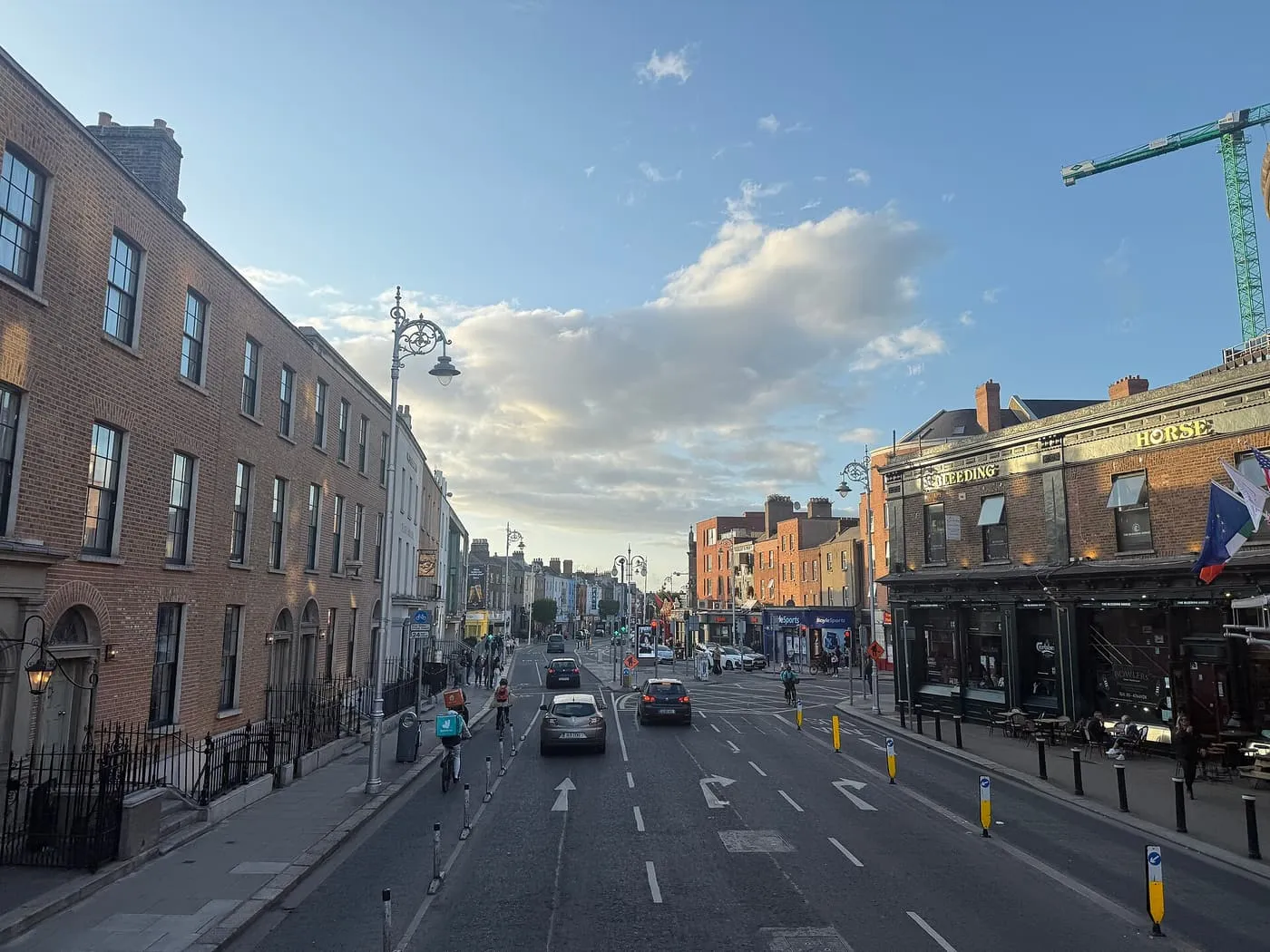 Camden Street in Dublin on a sunny evening, with a terrace of brick houses on the left and a pub on the right