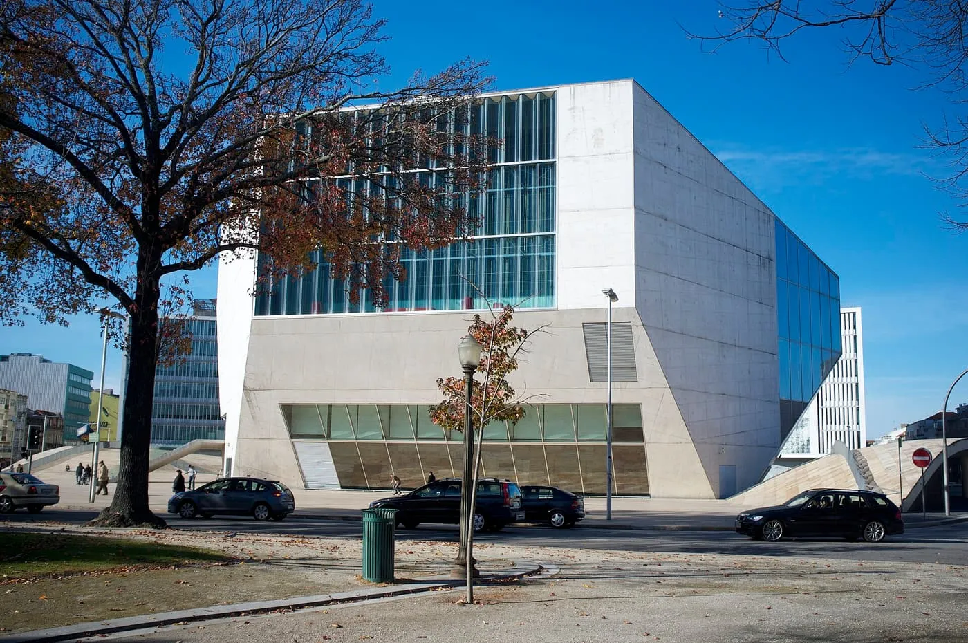 The white concrete faceted block of Casa da Música with a glazed upper floor, seen from the street