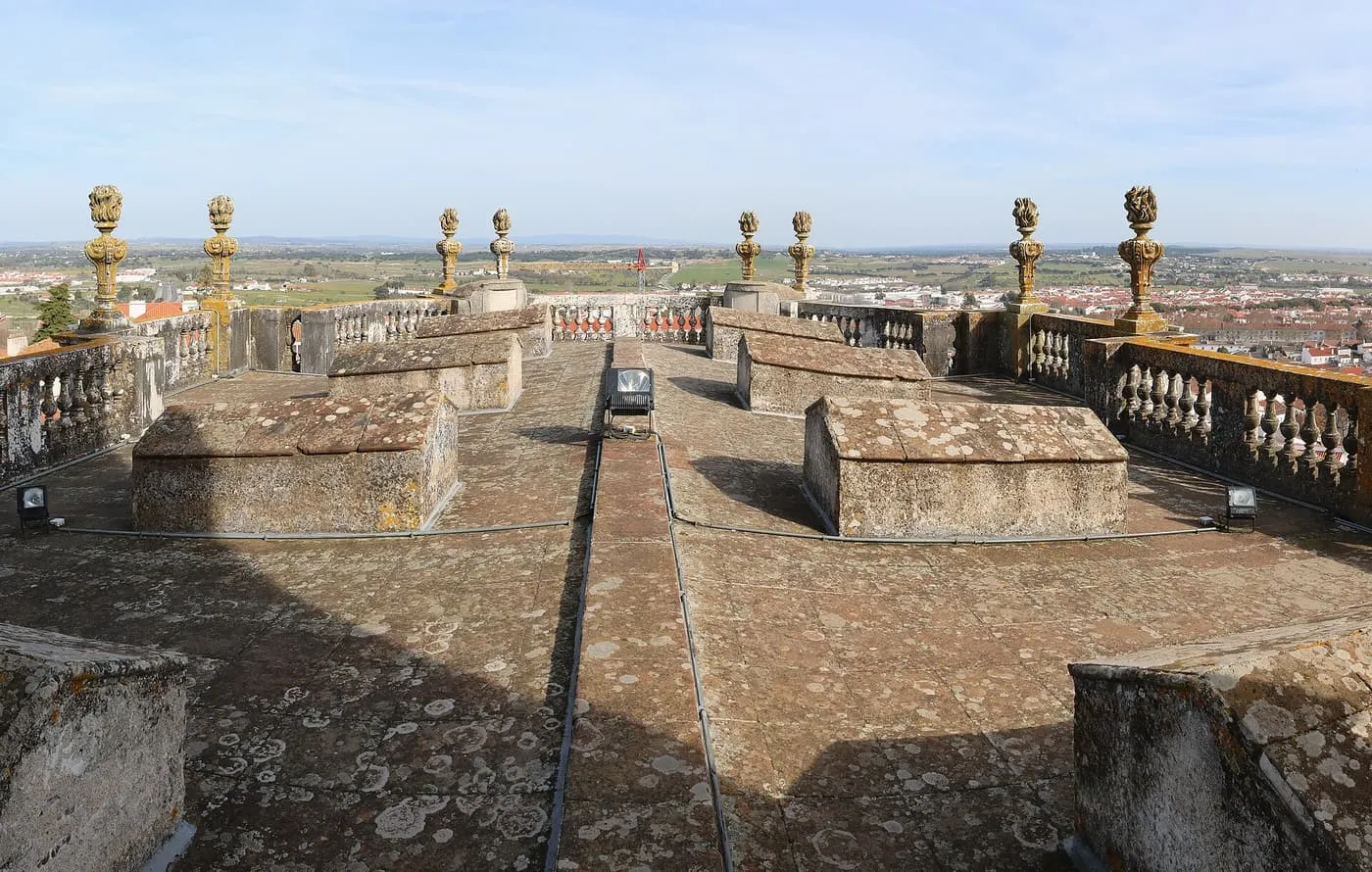 The stone roof terrace of Évora Cathedral, with carved pinnacles and balustrades, and the Alentejo plain beyond