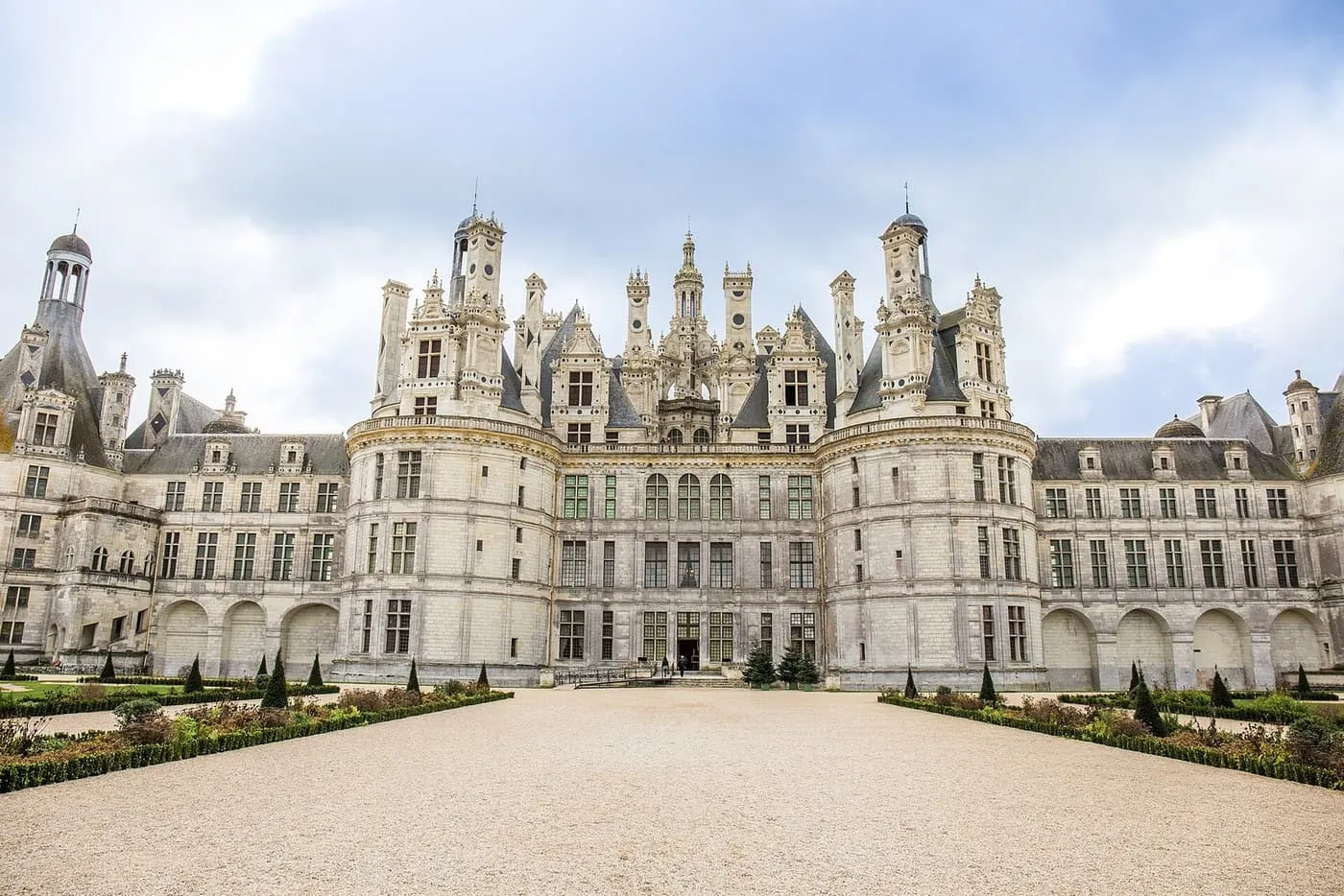 The Château de Chambord, with its round corner towers and crowded rooftop of chimneys and turrets, behind a gravel forecourt