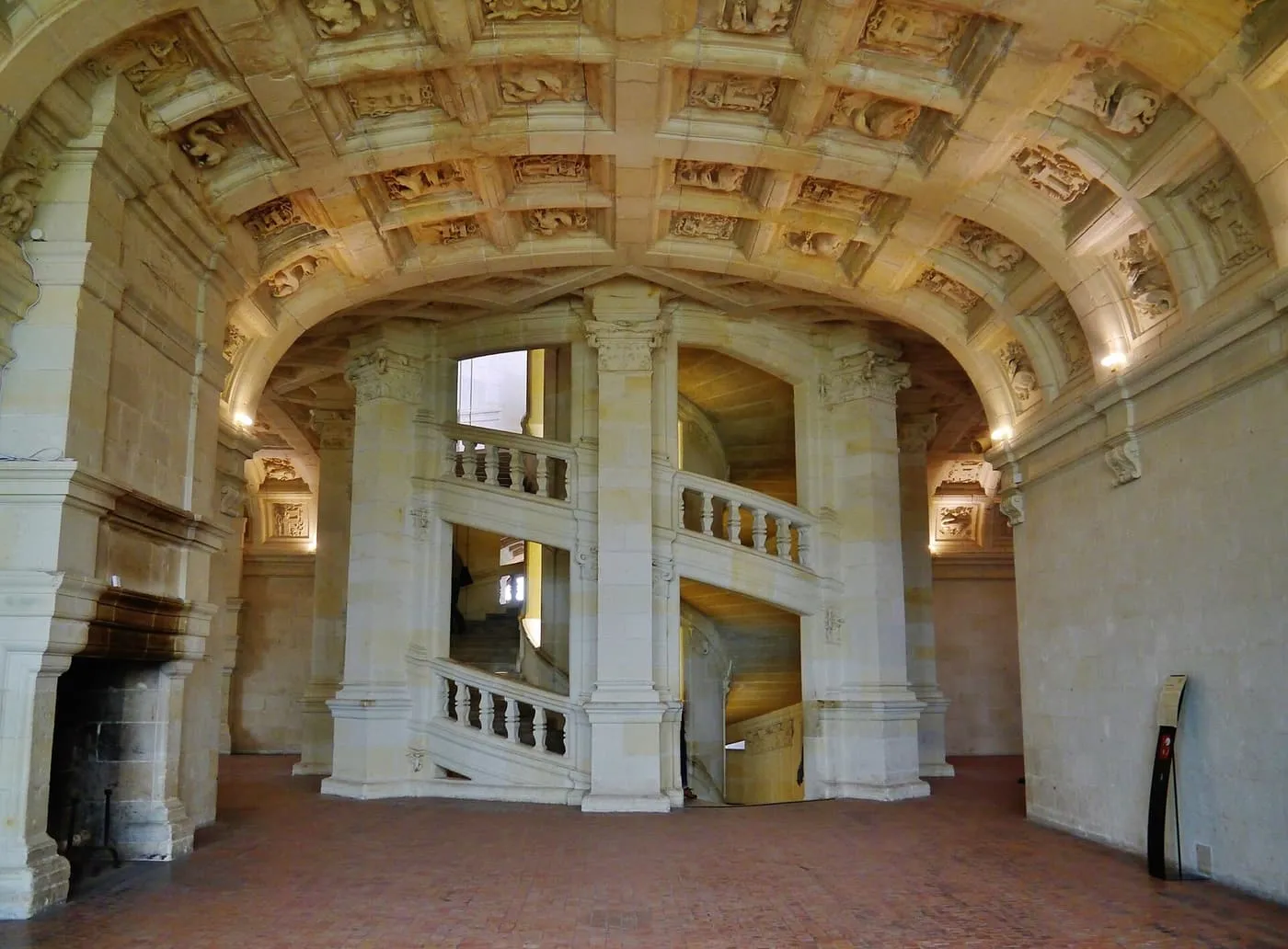 The central double-helix staircase at Chambord, its stone balustrades rising through a hall with a coffered vault