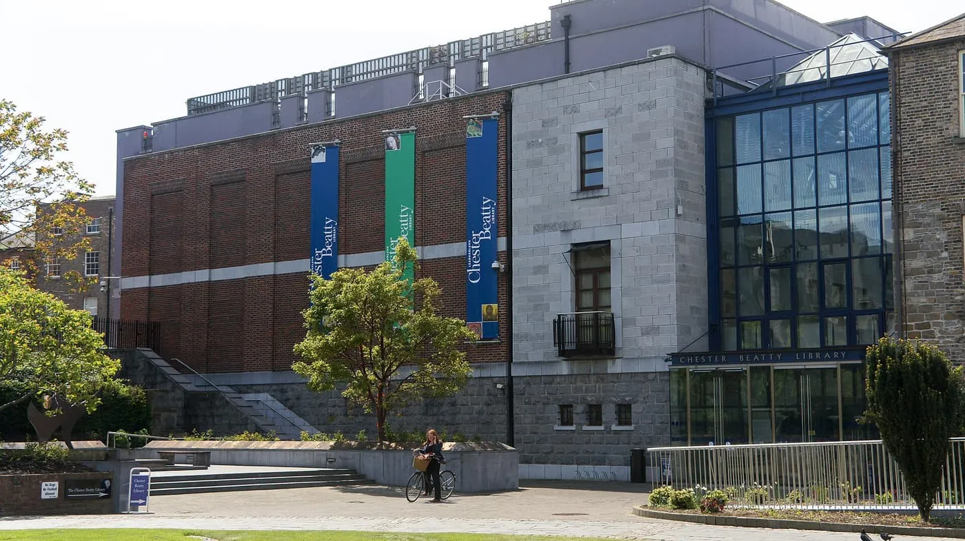 The Chester Beatty building in the grounds of Dublin Castle, with brick and stone walls, a glass front and blue banners