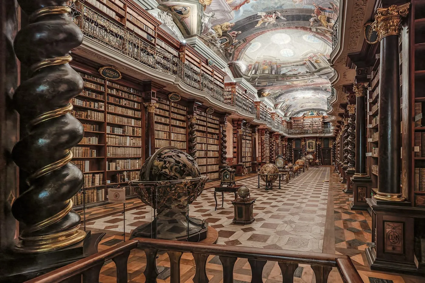 The Baroque Library Hall of the Clementinum, a long hall of floor-to-ceiling bookshelves, gilded globes and a painted ceiling