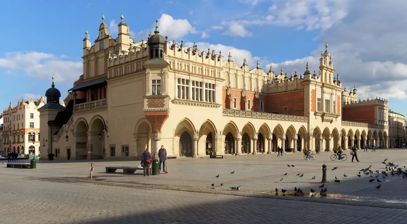 The Cloth Hall on the Main Market Square, with its arcade of pointed arches and decorated parapet in afternoon sun