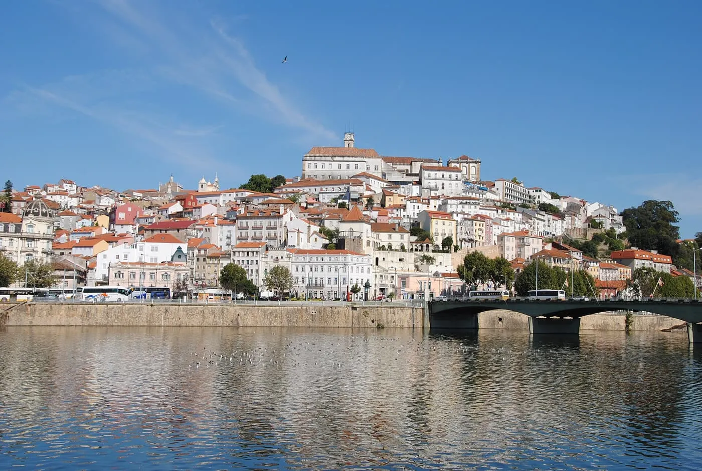 Coimbra rising up a hill above the Mondego, with the university tower at the top and a bridge across the river