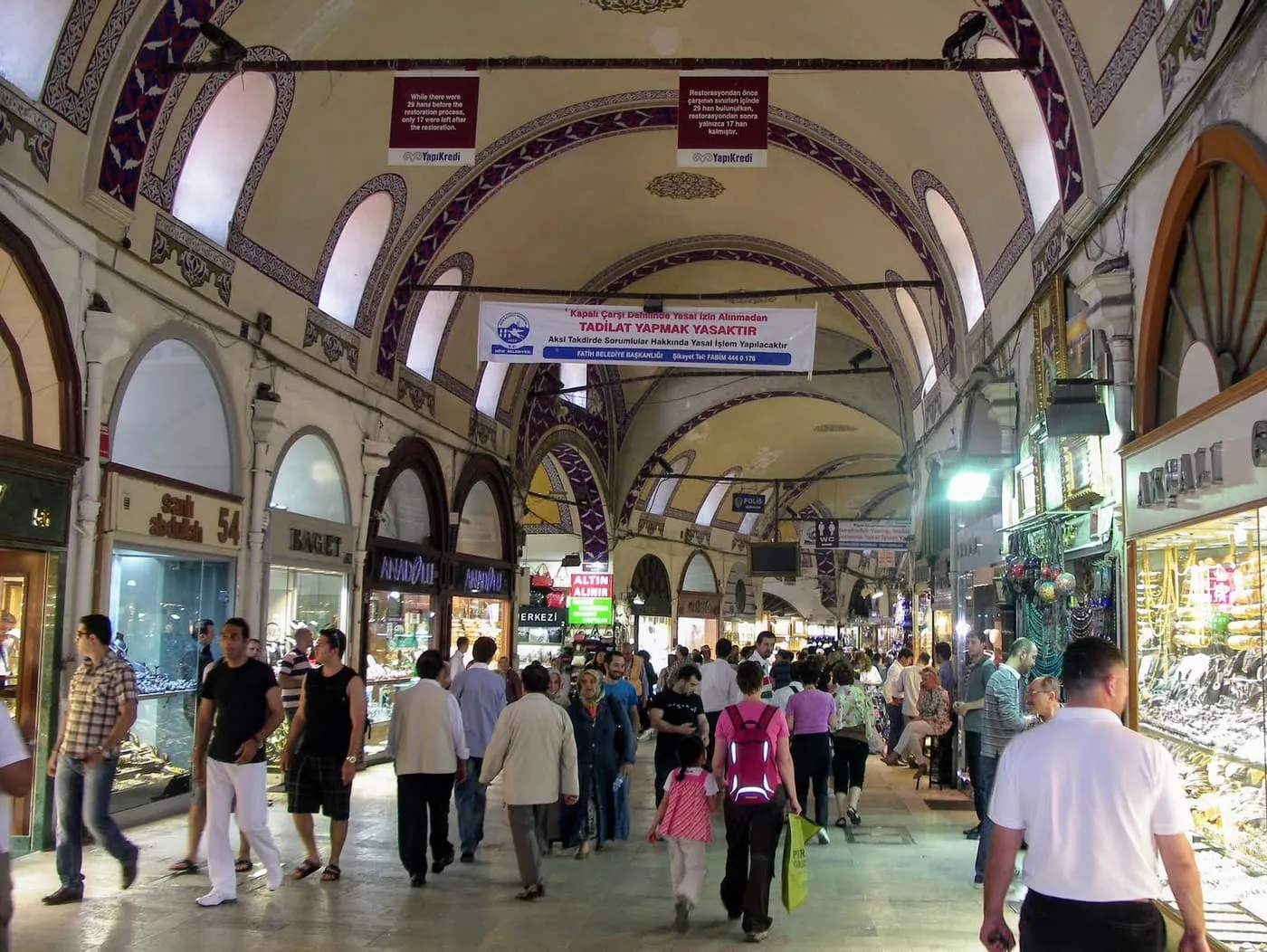 A vaulted street inside the Grand Bazaar lined with jewellery shops and busy with shoppers