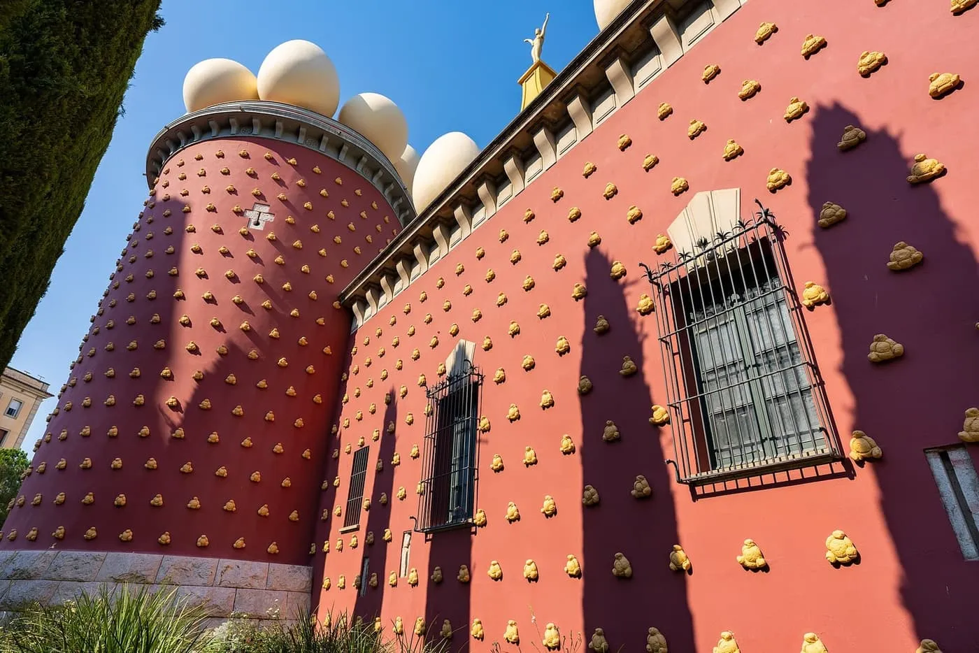 The red walls of the Dalí Theatre-Museum in Figueres, studded with gold bread-roll shapes and topped with giant white eggs