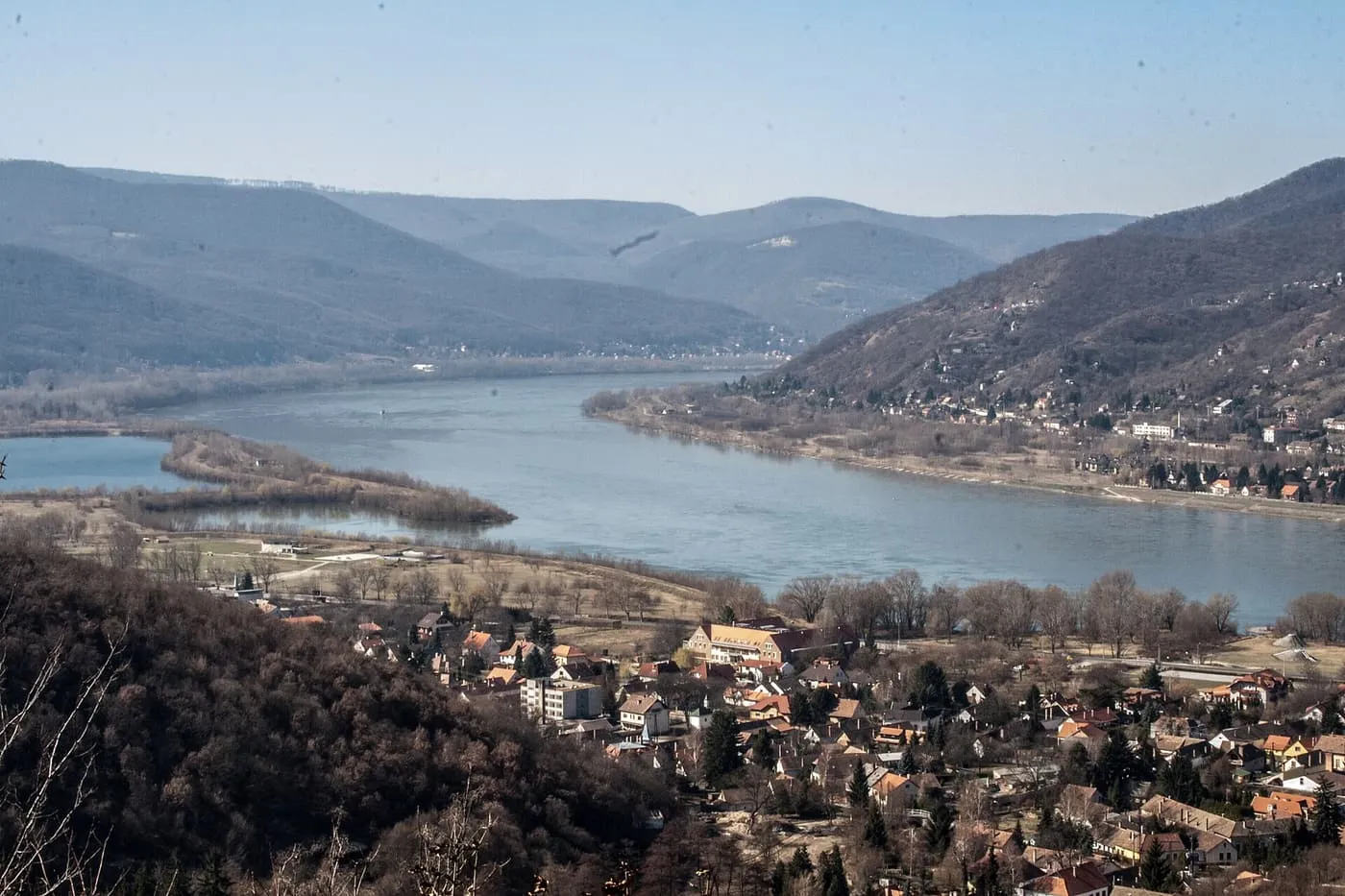The Danube curving between wooded hills at the Danube Bend, with the roofs of Visegrád below