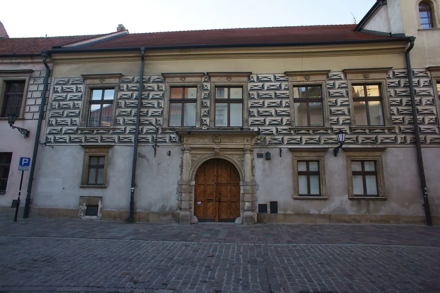 The Dean's House on Kanonicza Street, a long two-storey building with black and white sgraffito patterns round the windows and a stone portal
