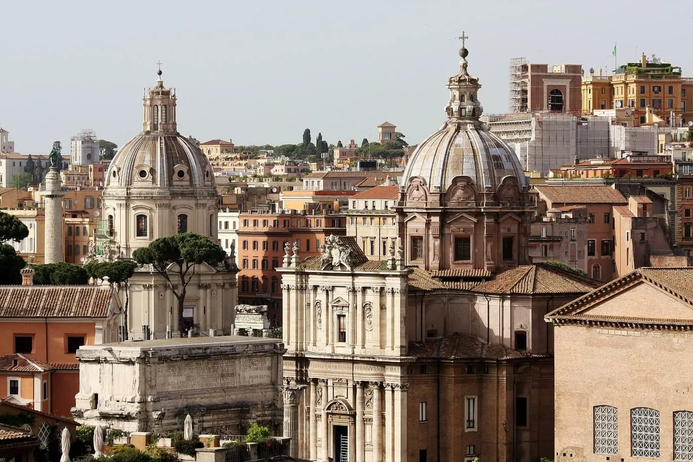 Two baroque domes and Trajan's Column above the rooftops near the Roman Forum
