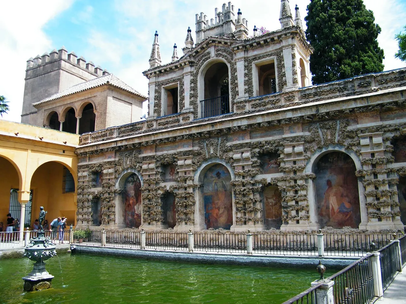 The grotto-work gallery above the green Estanque de Mercurio pond in the Real Alcázar gardens
