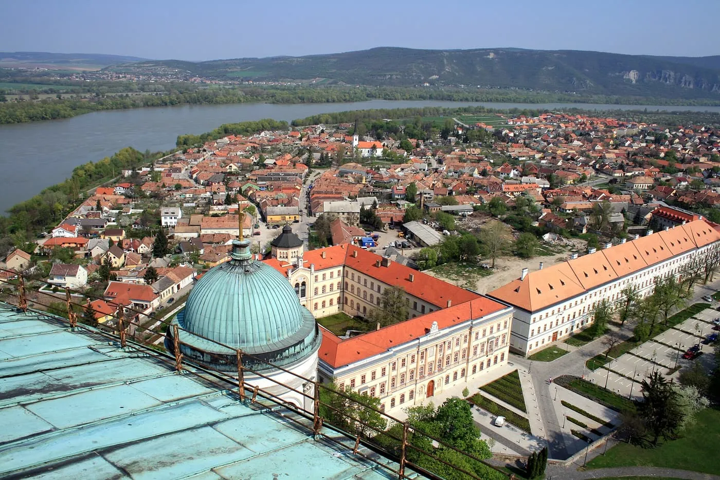 The Danube beside Esztergom, with red-roofed town houses and a green copper dome of the Basilica in the foreground