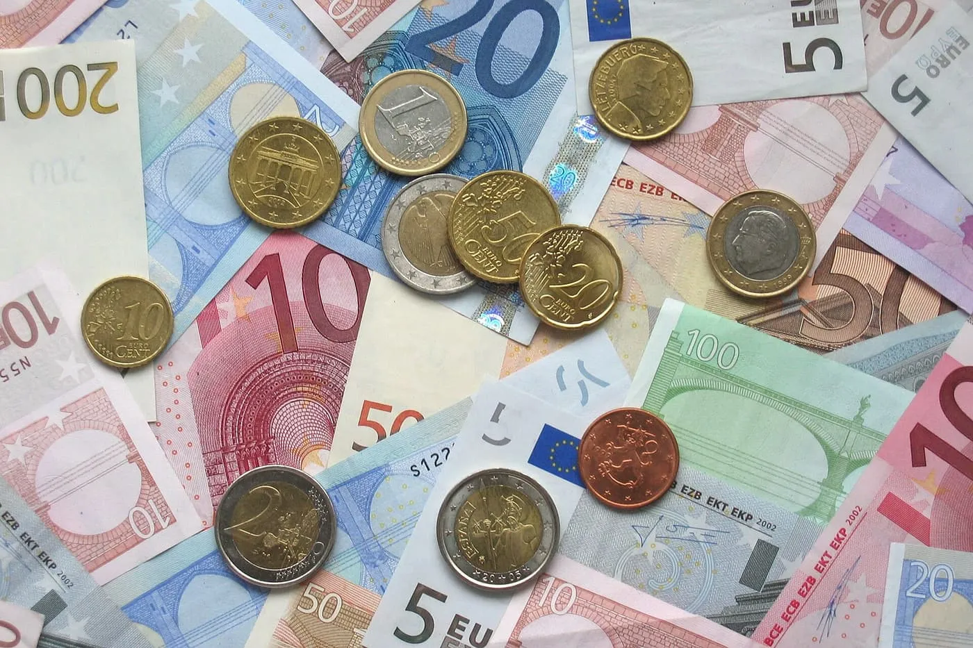 Euro coins of several values scattered over euro banknotes