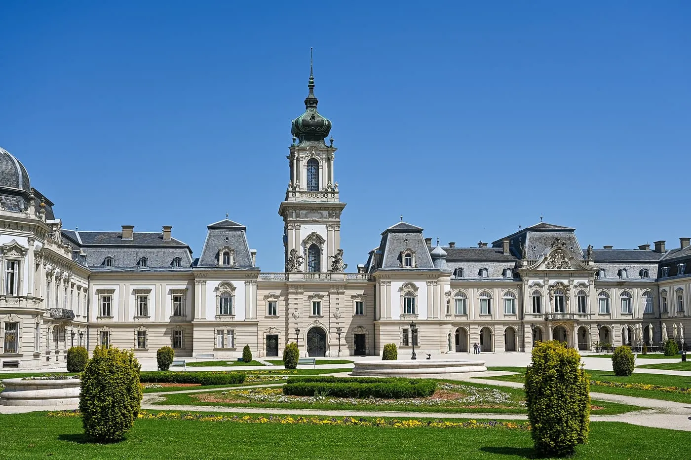 The Festetics Palace in Keszthely, with its clock tower and a formal garden in front