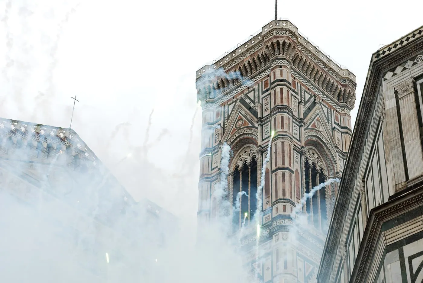 Smoke and fireworks rising beside Giotto's Bell Tower during the Scoppio del Carro