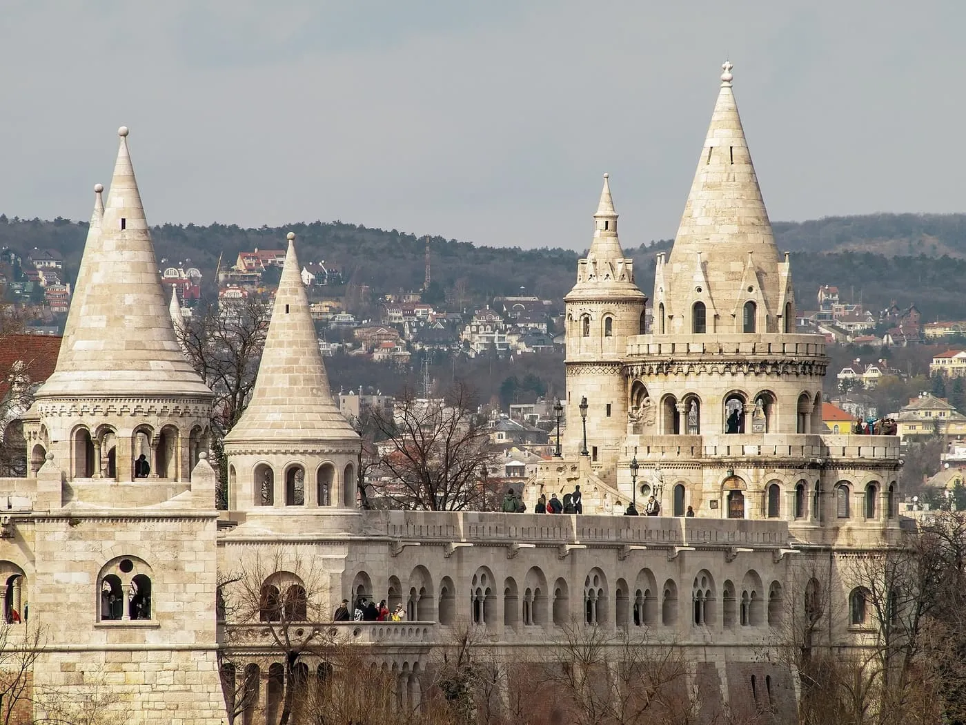 The white cone-roofed towers of Fisherman's Bastion above a long arcaded terrace, with the Buda hills behind
