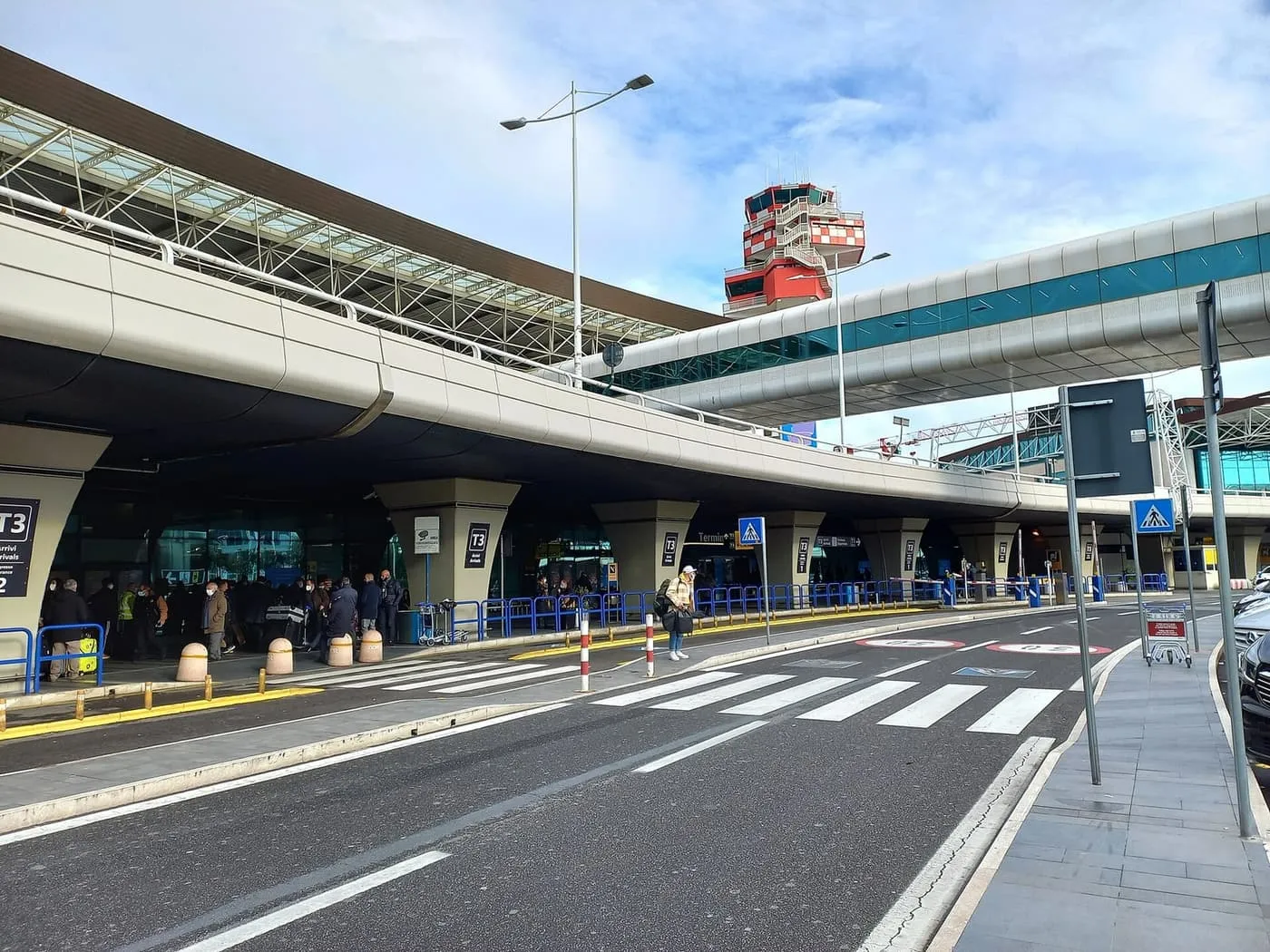 The arrivals road and elevated forecourt at Terminal 3 of Fiumicino airport, with the control tower behind