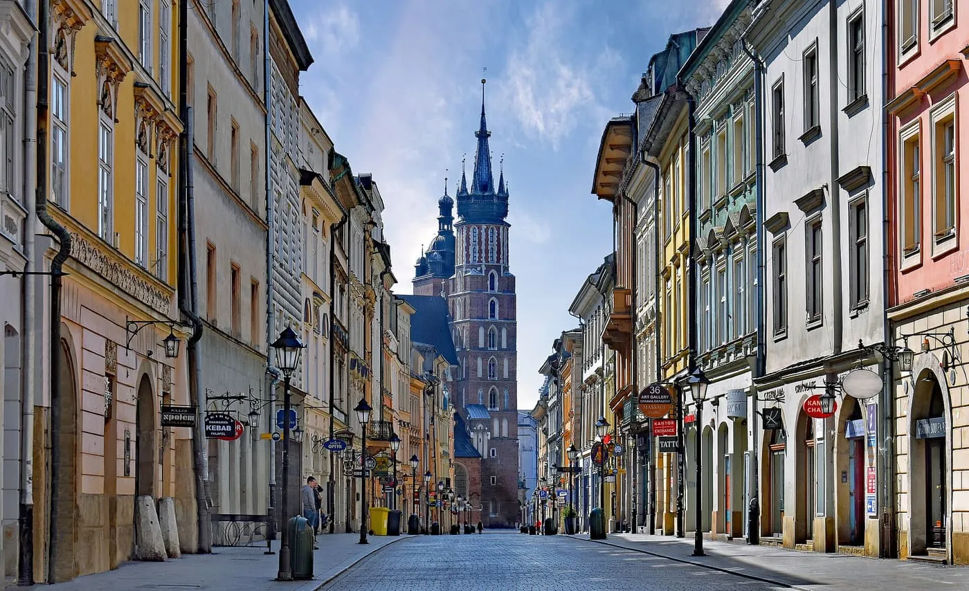 Floriańska Street empty of people, with tall painted townhouses on both sides and the spires of St Mary's Basilica at the far end