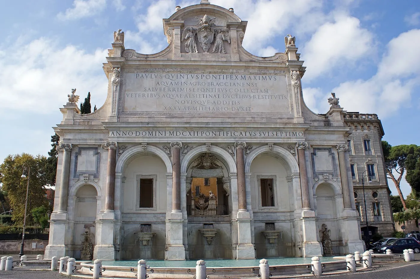 The Fontana dell'Acqua Paola, a white marble triple arch with an inscription across the top and a basin in front