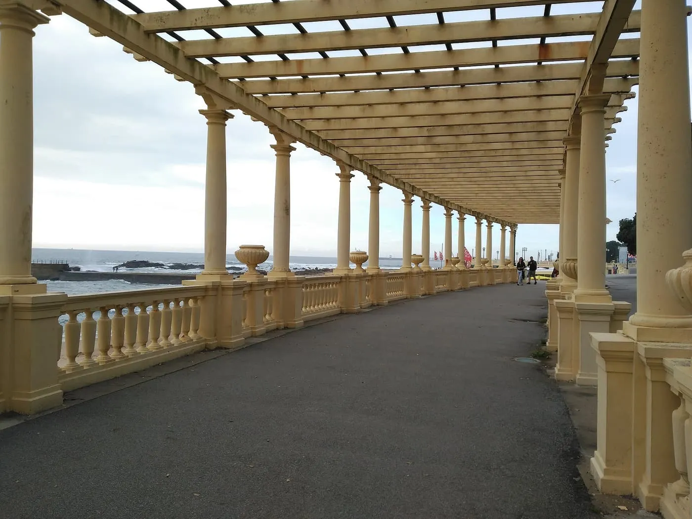 The Pérgola da Foz, a curved promenade lined with cream columns under a timber pergola beside the Atlantic