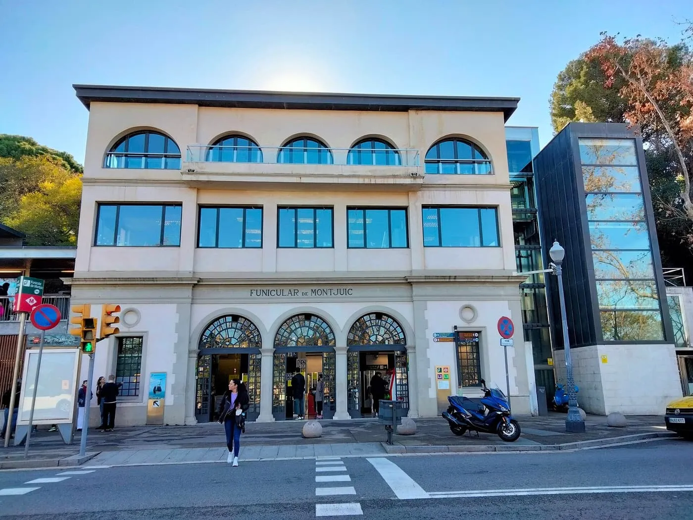 The cream-coloured upper station of the Montjuïc funicular on Avinguda de Miramar, with arched windows, a glass lift tower and its name on the façade