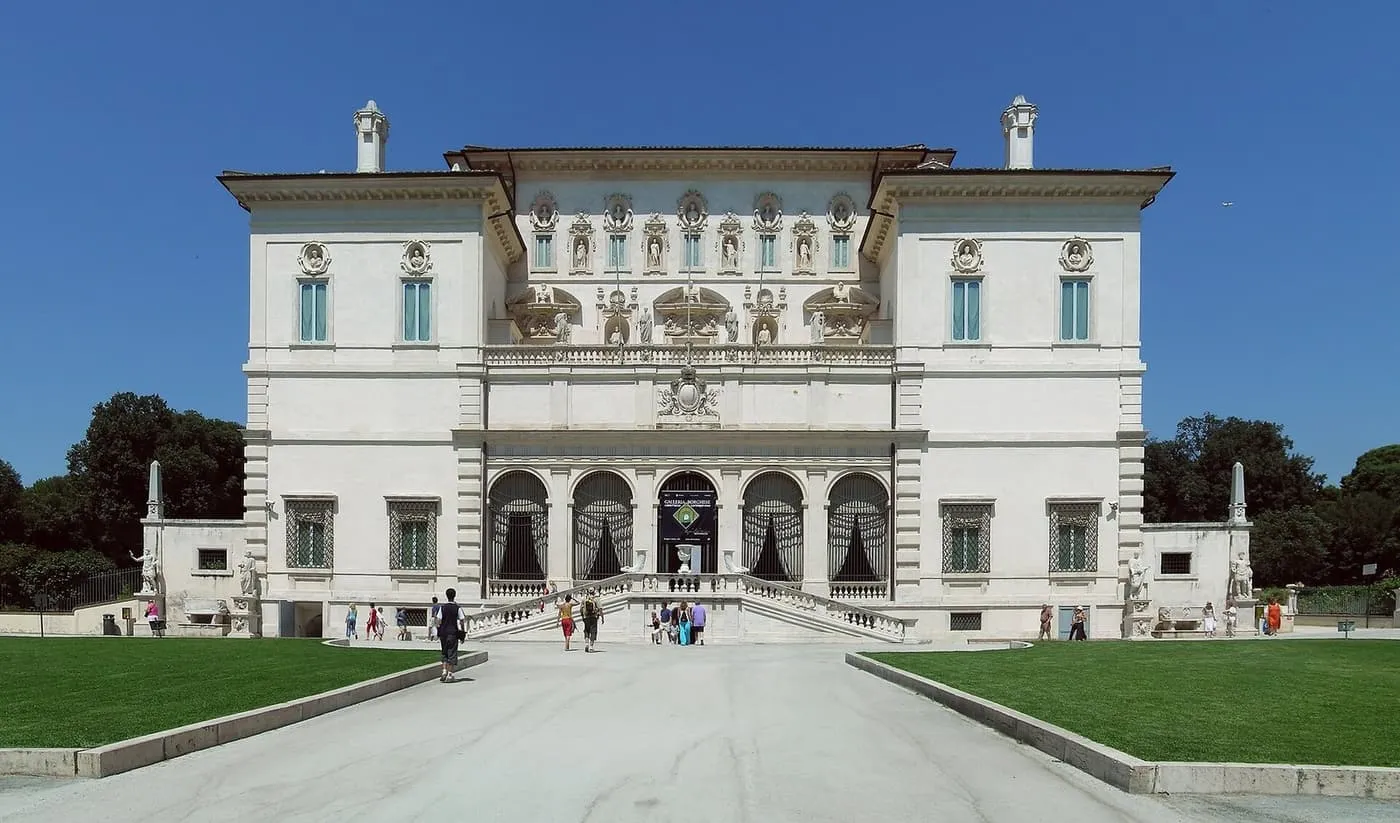 The white front of the Galleria Borghese, with a double staircase up to five arched openings and visitors on the drive in front