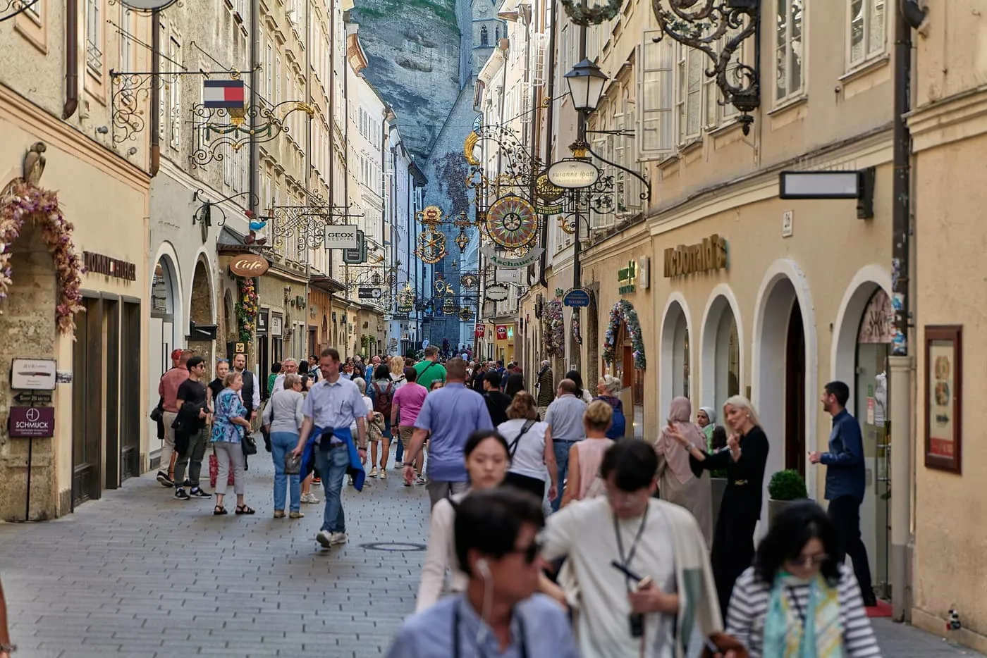 Getreidegasse, a narrow pedestrian street with wrought-iron guild signs hanging above the shop fronts