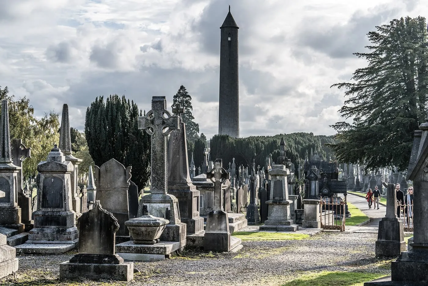 The tall round O'Connell Tower rising above gravestones and Celtic crosses in Glasnevin Cemetery