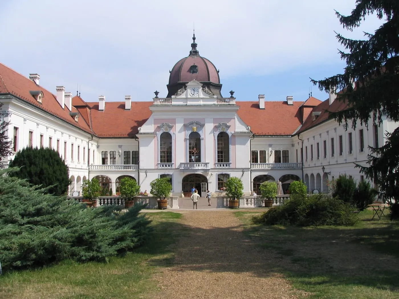 The pink and white Grassalkovich palace at Gödöllő, seen up a gravel path from the park