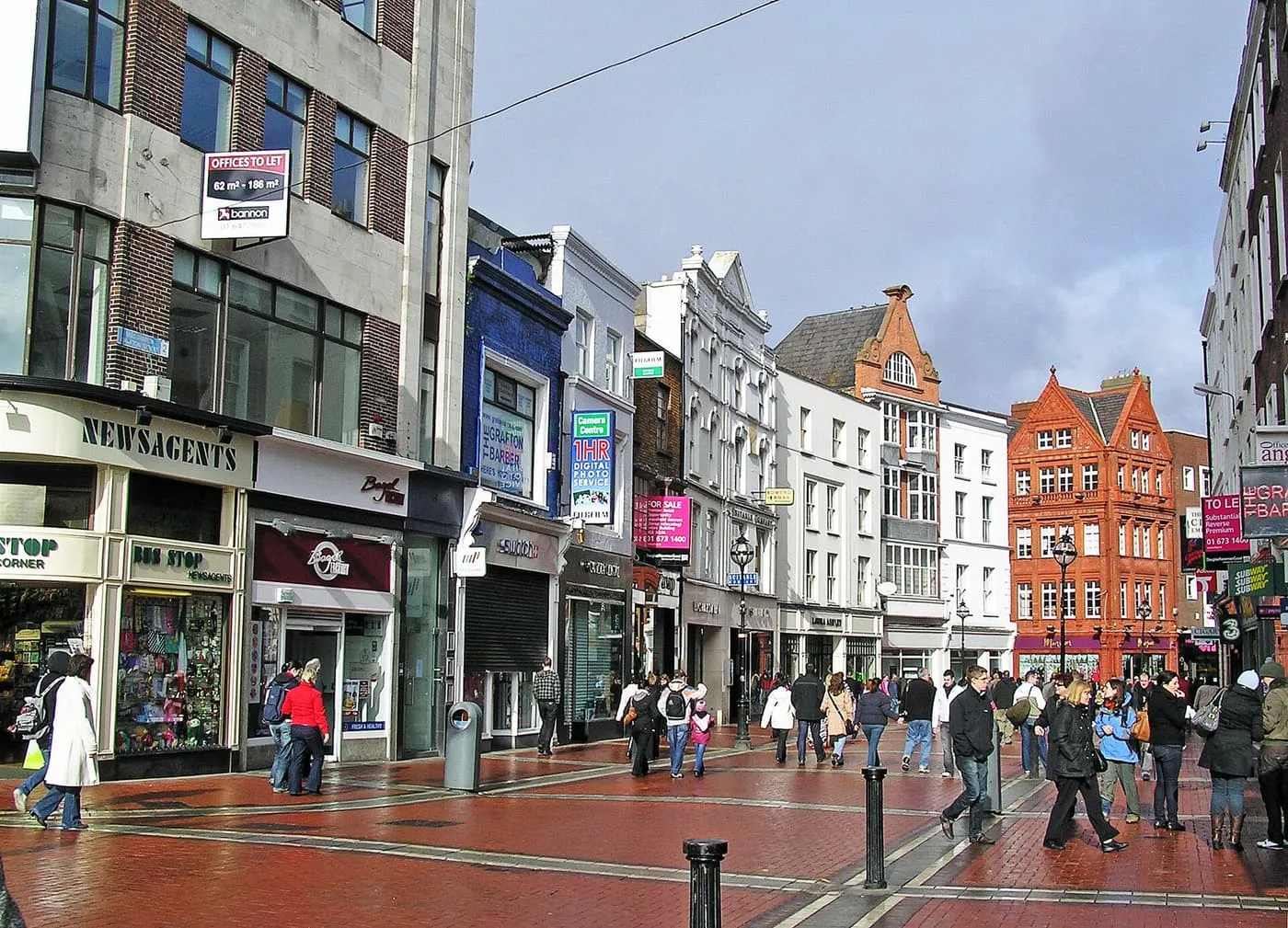 Shoppers on pedestrianised Grafton Street, with red-brick paving and shopfronts on both sides
