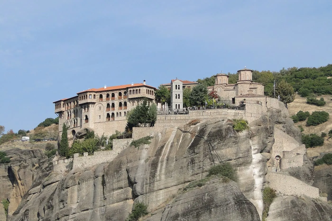 The Great Meteoron monastery, a long stone building and domed church on top of a tall sandstone rock pillar